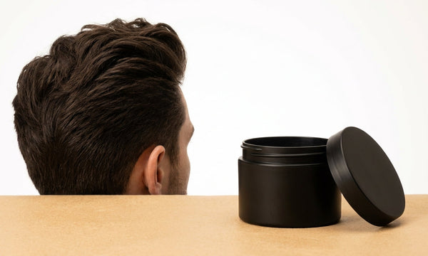 Man met volumineuze quiff naast een matte clay potje, gestyled met grip en textuur