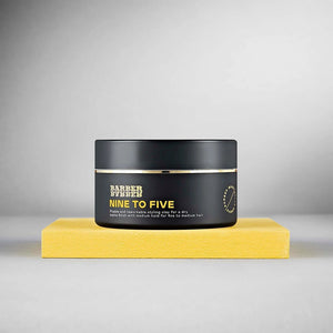 BARBER BARBER Nine To Five Medium Hold Styling Clay 100g - zwart potje op geel blok, grijze studio