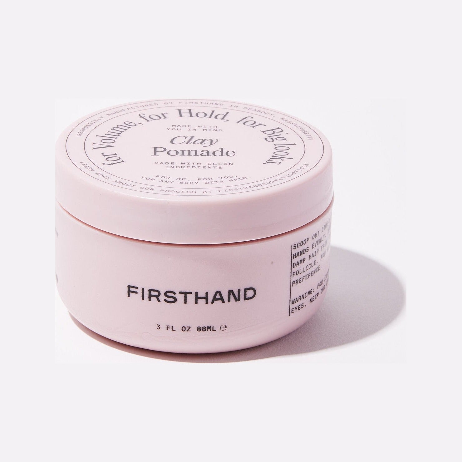 Firsthand Supply Clay Pomade - barattolo rosa inclinato con coperchio e nome del brand