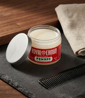 Royal Crown Pomade - barattolo aperto su ardesia con pettine, la pomata bianco crema visibile